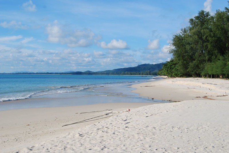 Szeroka, piaszczysta plaża w Khao Lak otoczona palmami i lazurowym morzem.