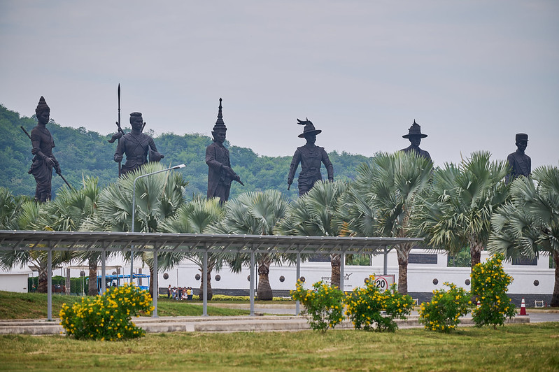 Ratchaphakdi Park w Hua Hin z posągami siedmiu wielkich królów Tajlandii na tle palm.