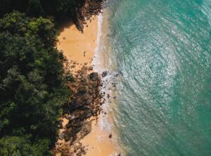 Malowniczy widok na wyspę Koh Phayam – piaszczysta plaża otoczona bujną roślinnością i turkusowym morzem.