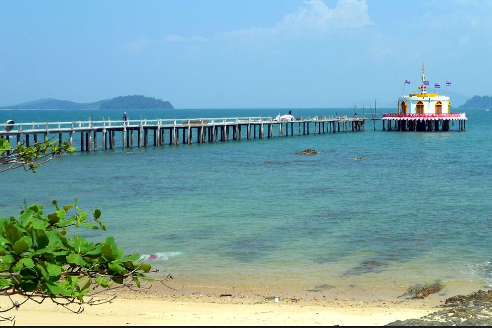 Długie molo na Koh Phayam prowadzące nad turkusową wodą w stronę morza.