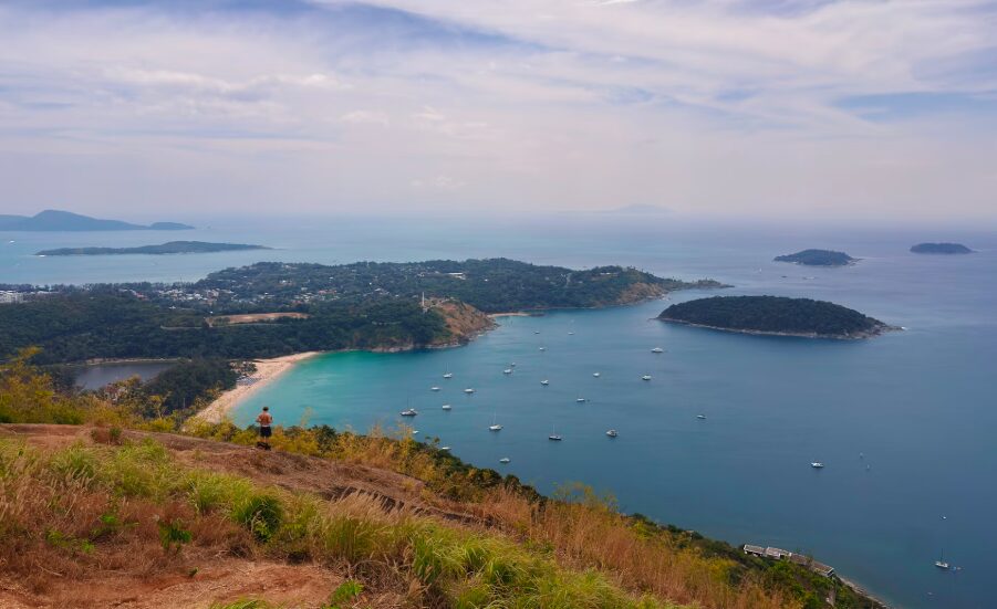  Malowniczy widok na Karon Beach na Phuket – turkusowe morze, złocista plaża i zielone wzgórza.