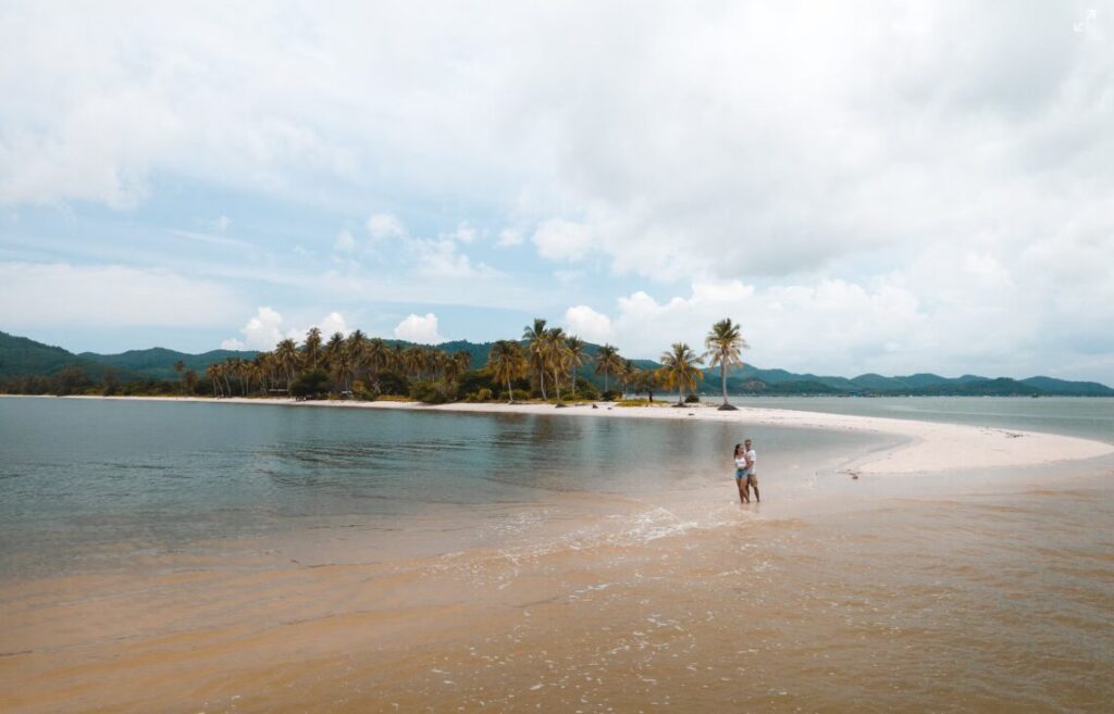 Piaszczysta mierzeja na Laem Had Beach na Koh Yao Yai otoczona turkusową wodą, z widokiem na pobliskie wyspy.