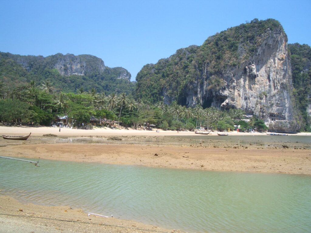 Plaża Tonsai w Krabi otoczona wapiennymi klifami i tropikalną roślinnością. Spokojna zatoka z turkusową wodą i złotym piaskiem, popularna wśród wspinaczy i miłośników natury.