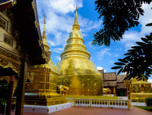 Złota stupa i świątynia Wat Phra Singh w Chiang Mai, oświetlona wieczorem.