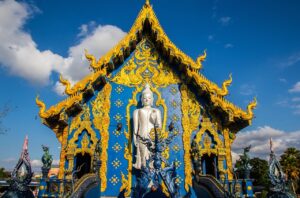 Niebieska Świątynia (Wat Rong Suea Ten) w Chiang Rai, zdobiona intensywnie błękitnymi i złotymi detalami, będąca jednym z najciekawszych współczesnych miejsc sakralnych w Tajlandii.