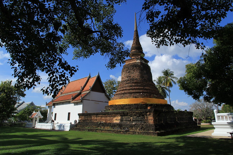 Świątynia Wat Traphang Thong w Sukhothai, z charakterystyczną stupą otoczoną zielenią.