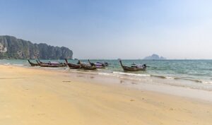 Plaża Ao Nang w Krabi – szeroka, piaszczysta plaża otoczona wapiennymi klifami, z widokiem na Morze Andamańskie.