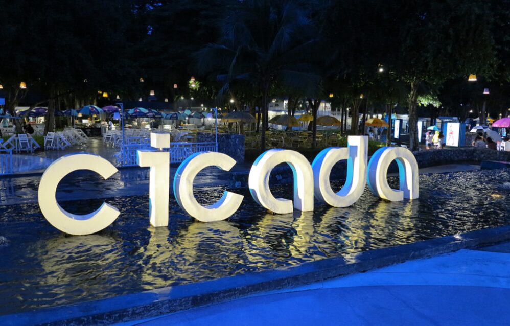 Nocny targ Cicada Market w Hua Hin, podświetlone logo na tle nocnego krajobrazu.