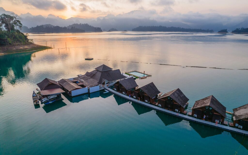 Domki na wodzie na jeziorze Cheow Lan w Parku Narodowym Khao Sok, otoczone górami i dżunglą.