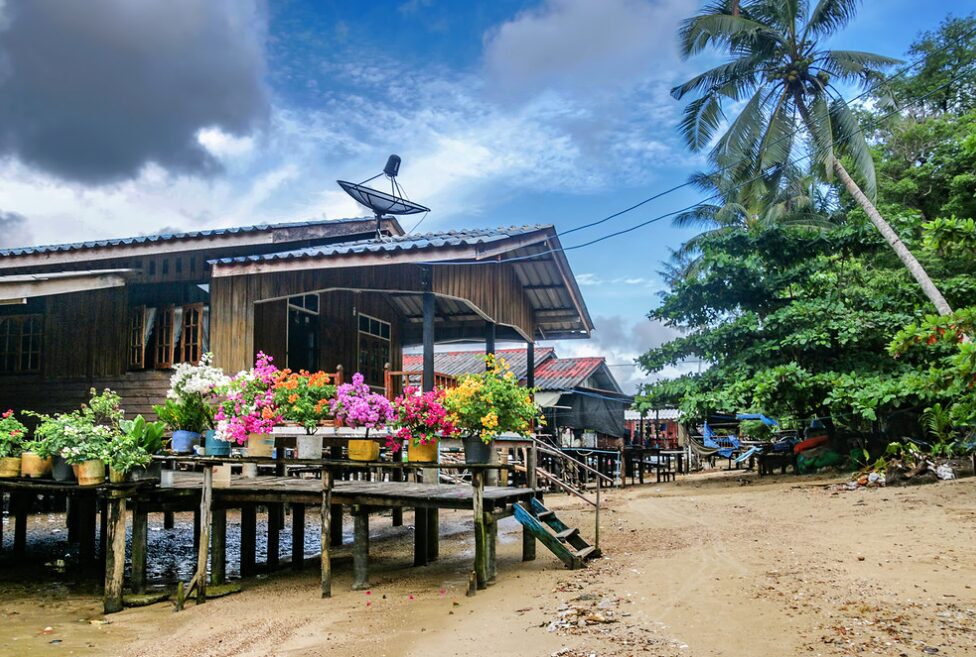 Tradycyjna bambusowa chatka na plaży na Koh Mook, otoczona palmami i egzotycznym krajobrazem.