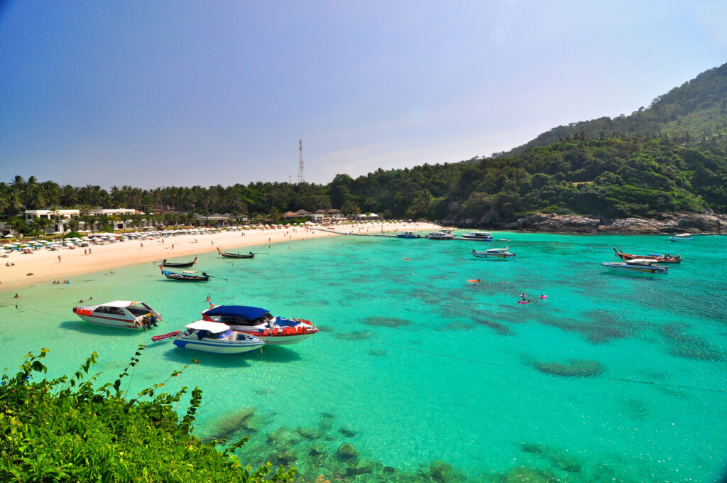 Turkusowa zatoka z łodziami przy plaży na Racha Island niedaleko Phuket, Tajlandia.