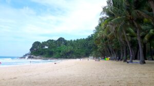 Plaża Surin na Phuket – spokojna zatoka z jasnym piaskiem, turkusową wodą i otaczającą zielenią.